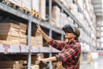 Young africn woman wearing virtual reality (VR) goggles stands in middle of warehouse with shelves stocked, traditional workwear and modern technology, technology logistics in industrial and warehouse