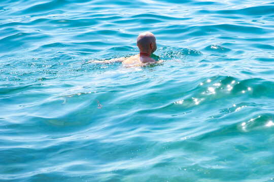 Young swimmer in sea, ocean, man engaged in water sports, struggling against dangerous currents, warning about dangers unseen forces, active lifestyle