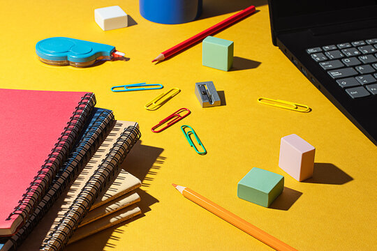 Colorful school supplies arranged on a yellow background