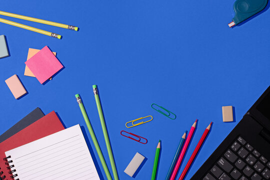Colorful school supplies organized on a blue background