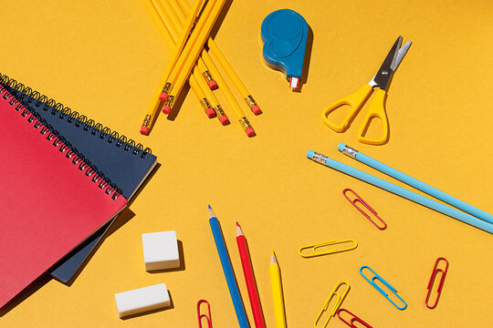 Colorful school supplies arranged on a yellow background