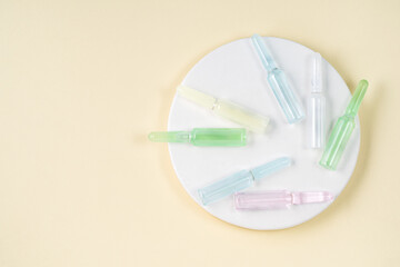 Top view of colorful glass ampoules on a white plate