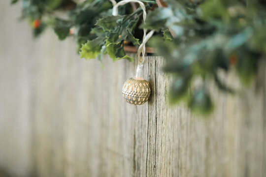 Mistletoe and delicate Christmas lights strewn along rustic wooden seat