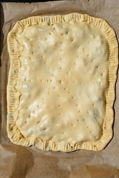 Unbaked soparnik on a baking tray - traditional Croatian chard and onion pie