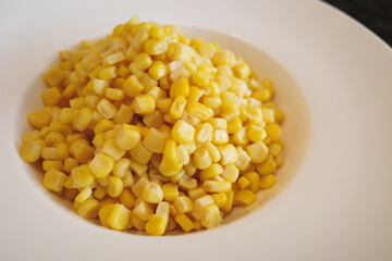 Boiled sweet corn kernels on white dish 