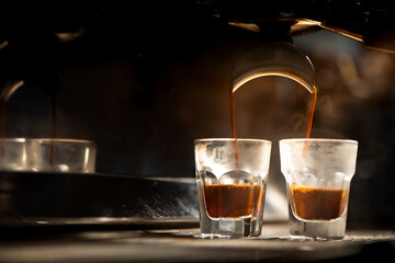 Espresso machine brewing coffee into a glass.