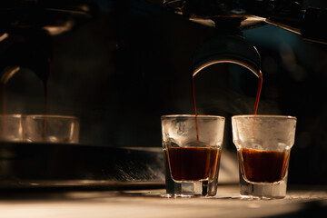Espresso machine brewing coffee into a glass.
