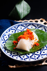 Food concept thai snack or dessert Kao Niew Na Koong  coconut Gelatinous or sticky  rice with shrimp topping on banana leave  on black background