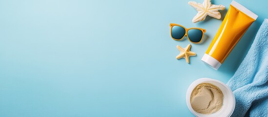 Baby sunscreen in a tube towel sunglasses and a bucket with sand molds on a blue background Flat lay top view copyspace