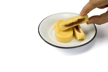 A woman hand pick up a piece of Taiwanese pineapple cake in white dish isolated on white background with clipping path closed up copy space
