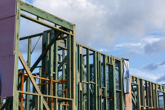 timber house frames on townhouses under construction on a sunny day