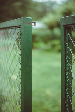 Close-up of an open green metal gate in a garden, Spain