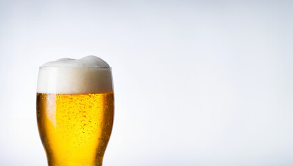 Isolated golden liquid in a glass pint with frothy white foam