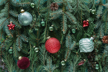 Full frame close-up of assorted Christmas conifer branches with a variety of colourful christmas bauble ornaments