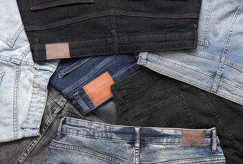 Assortment of many different fashionable jeans pants with with leather tags