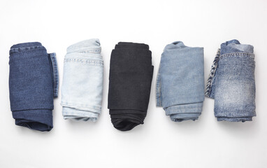 Rolled up jeans pants on a white background. Top view