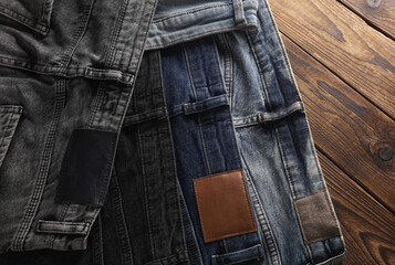 Many jeans pants on wooden background. Top view.