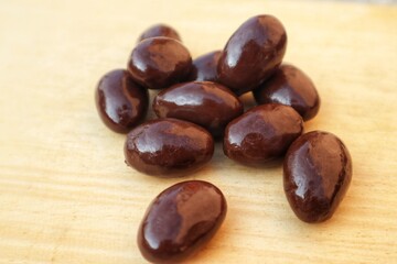 Some Almonds covered with dark chocolate close up view.