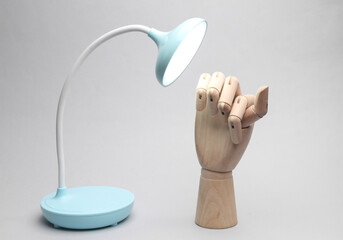 Table flexible wireless led lamp with wooden hand on a gray background