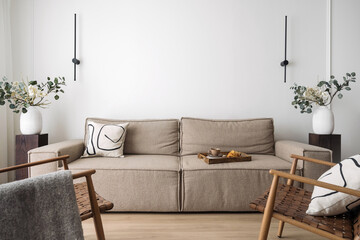 Interior with rattan chair, home decor and comfy couch in living room