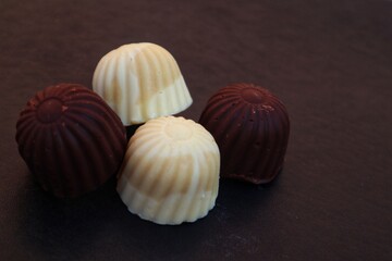 Sweet white chocolate candy and dark chocolate candy close up view.