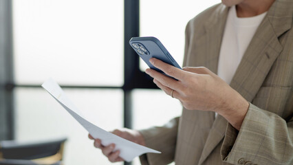 Businessman using mobile phone while working by connecting technology and synchronizing between...