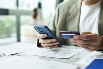 Close up hands using credit card for online purchasing on smartphone