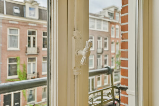 Classic white window latch with city view