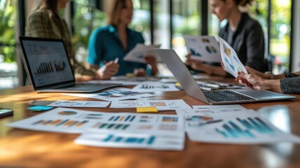 Photo-realistic image of a real estate team brainstorming marketing strategies with flyers, laptops, and charts on the table   Marketing planning, teamwork session