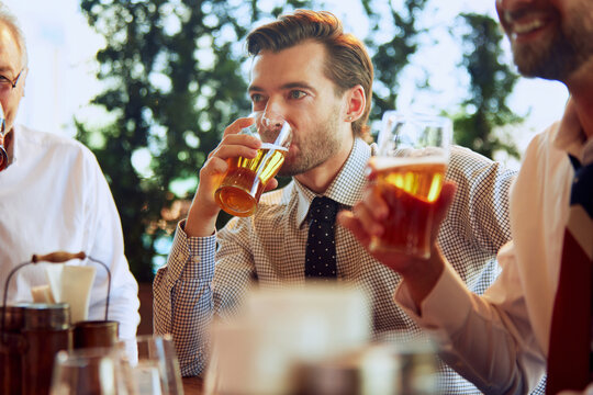 Group of businesspeople, colleagues meeting at local pub, drinking beer, relaxing, talking. Teamwork and partnership. Concept of business, meeting, fun, celebration, leisure time, Oktoberfest