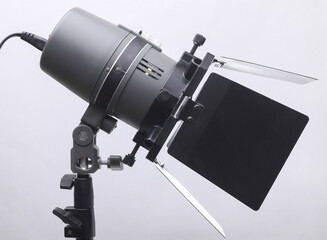 Professional studio light with curtains on a tripod on a gray background