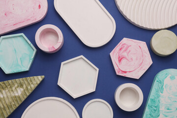 Plaster geometric shapes, decorative trays on blue background. Top view