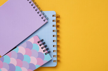 Various notepads on a yellow background.