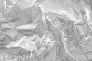 Close-up of Crumpled Silver Foil Wrapping Paper Texture with Wavy Metallic Surface