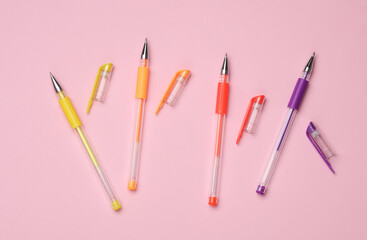Colored pens on a pink background. Top view