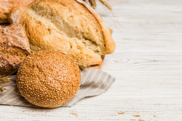 Homemade natural breads. Different kinds of fresh bread as background, perspective view with copy space