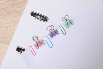 White blank sheets of paper with colored paper clips and binders