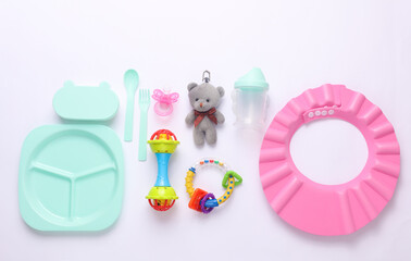 Toys for newborns, feeding accessories on a white background. Flat lay