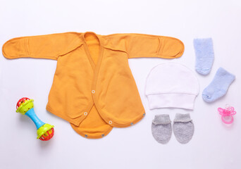 Set of newborn clothes, accessories and toys on a white background. Flat lay. Top view