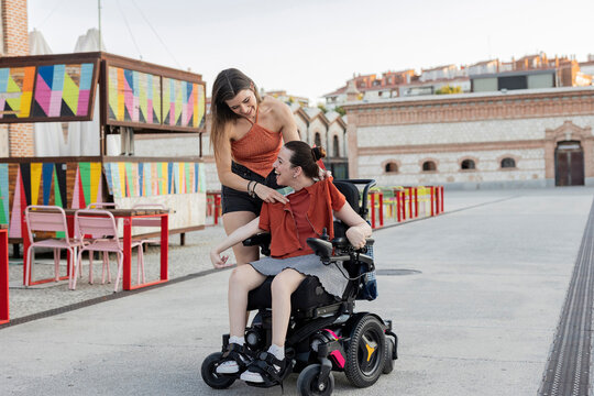 Two friends enjoying a moment together, one using a wheelchair