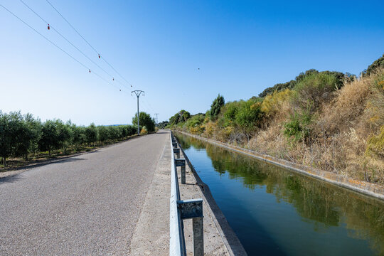 Rural irrigation canal alongside road and fields