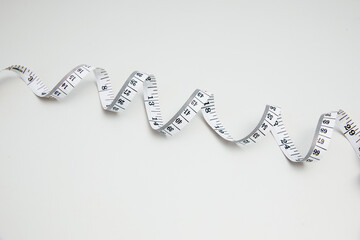 Curled measuring tape on clean white background