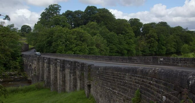 side on shot of grassington bridge showing the road with cars going left to right in the Yorkshire Dales