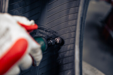 Close up view of damaged car tire being repaired in workshop.