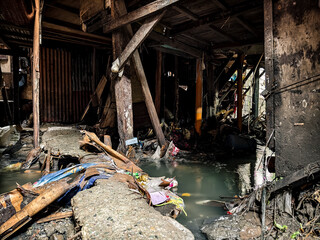 Metro Manila, Philippines - Aug 28, 2024: A murky, debris and garbage filled creek flows beneath a...
