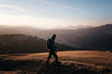 Fototapeta premium Solo Hiker Walking at Sunset on Mountain Ridge