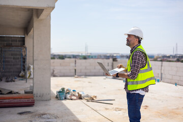 Professional Mechanical Engineer Working on Personal laptop computer at house construction site. Product quality Inspection