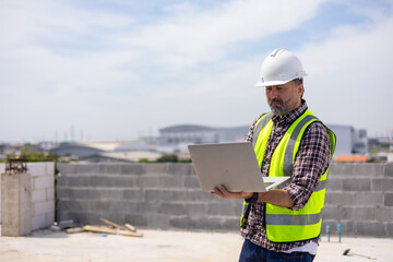 Professional Mechanical Engineer Working on Personal laptop computer at house construction site. Product quality Inspection