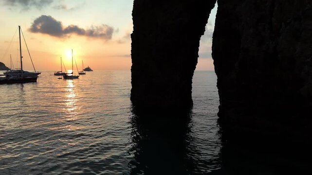 Risveglio all'alba nella baia dell'Arco Naturale dell'isola di Ponza, Italia, Mar Tirreno, Mediterraneo.
Le barche ancorate nella baia pi&ugrave; suggestiva di Italia in una mattina d'estate col sole giallo.