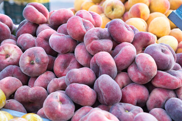 Piles display of fresh peaches and apricots.